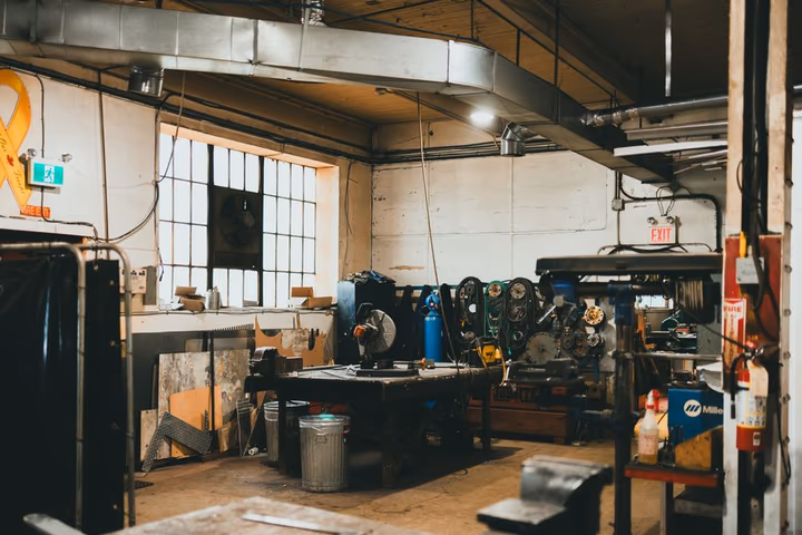 Atelier industriel aux tons chauds, outils et équipements soigneusement rangés sur des étagères.